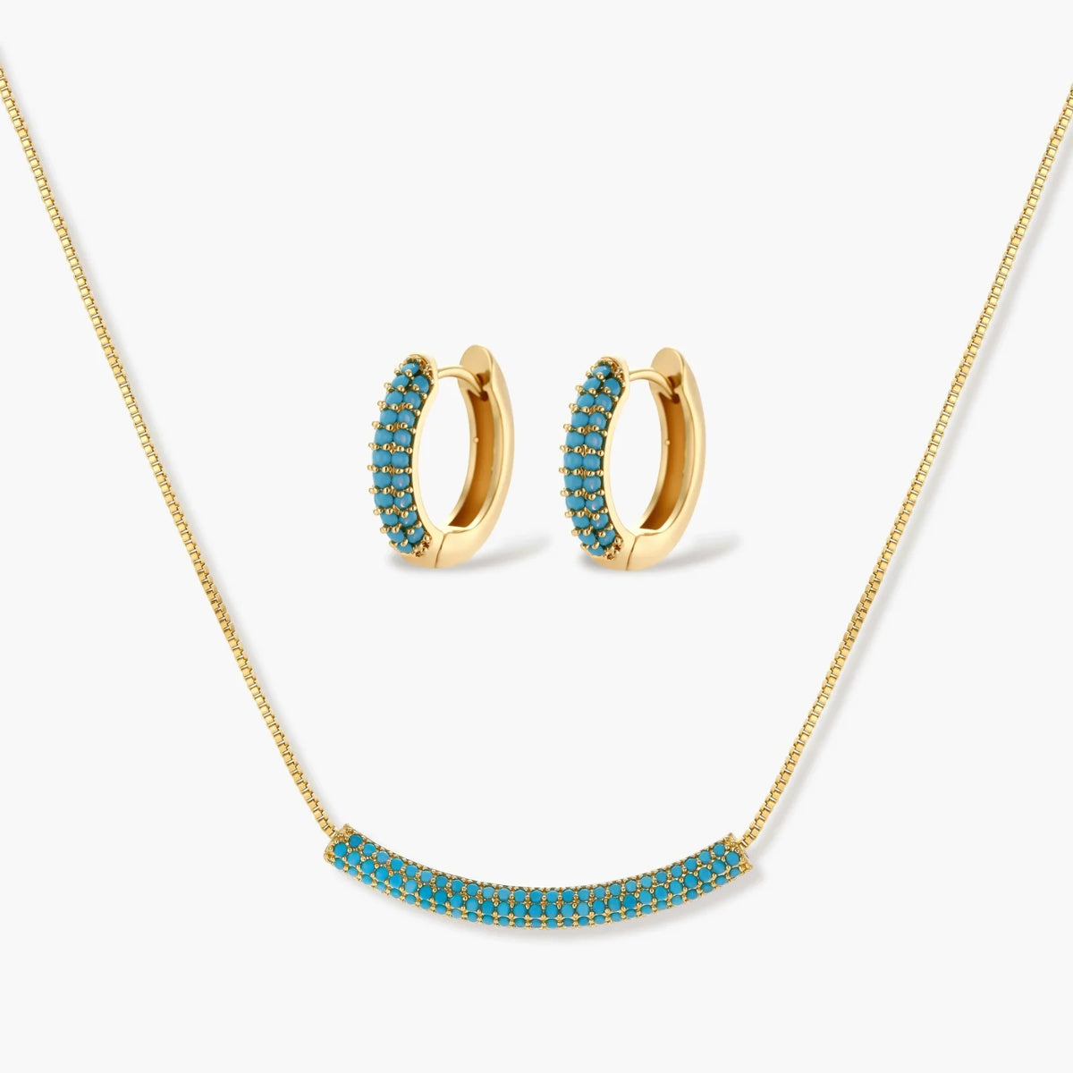 Gold-plated curved necklace and hoop earrings with turquoise cubic zirconia stones on white background.