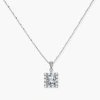 Square moissanite pendant with halo setting on delicate sterling silver chain against white background.