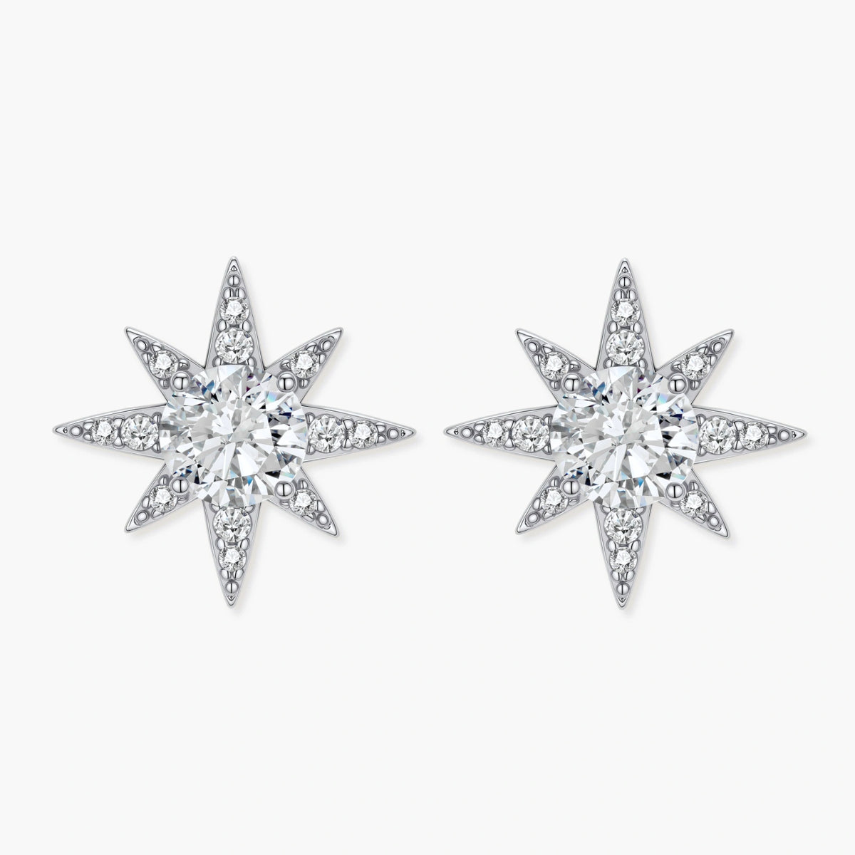 Sterling silver star-shaped stud earrings with brilliant moissanite center stones and pavé details on neutral background.