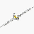 Sterling silver bracelet with yellow moissanite centerpiece in oval setting, crystal chain, and star charm on white background.