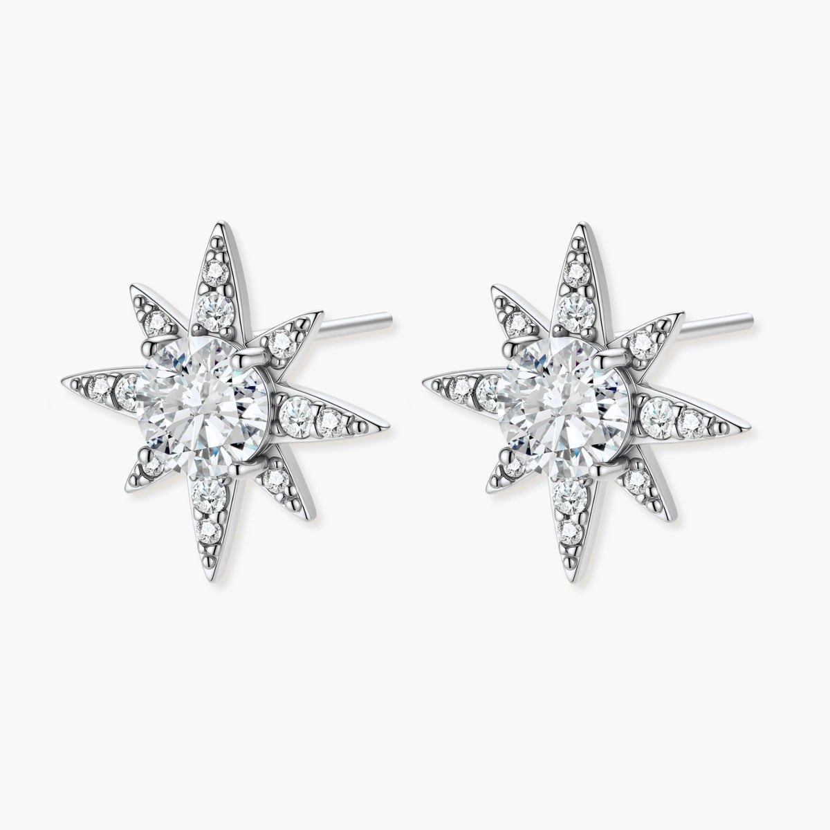 Sterling silver star-shaped stud earrings with brilliant moissanite center stones and pavé details on neutral background.