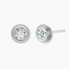 Close-up of sterling silver stud earrings featuring concentric circular frames with brilliant moissanite centers