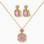 Ornate gold-plated jewelry set with rose pink zirconia center stones and crystal accents on cream background.