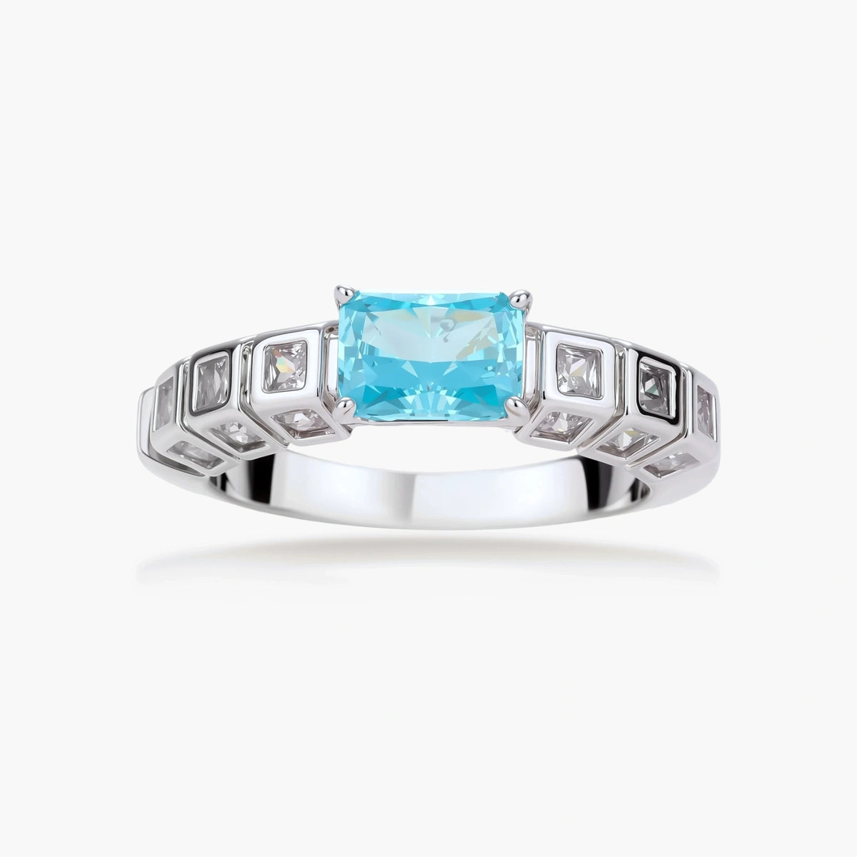 Geometric silver-plated ring with rectangular aqua cubic zirconia center and square crystal details on adjustable band.