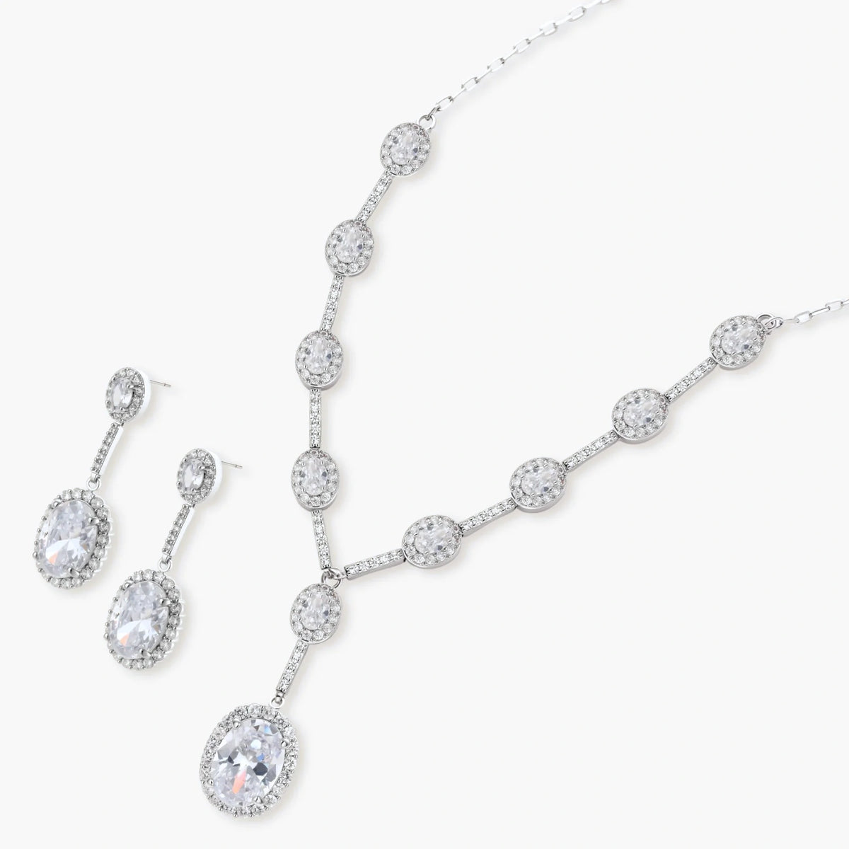 Elegant white gold plated jewelry set with oval cubic zirconia stones in halo settings, featuring Y-necklace and drop earrings.