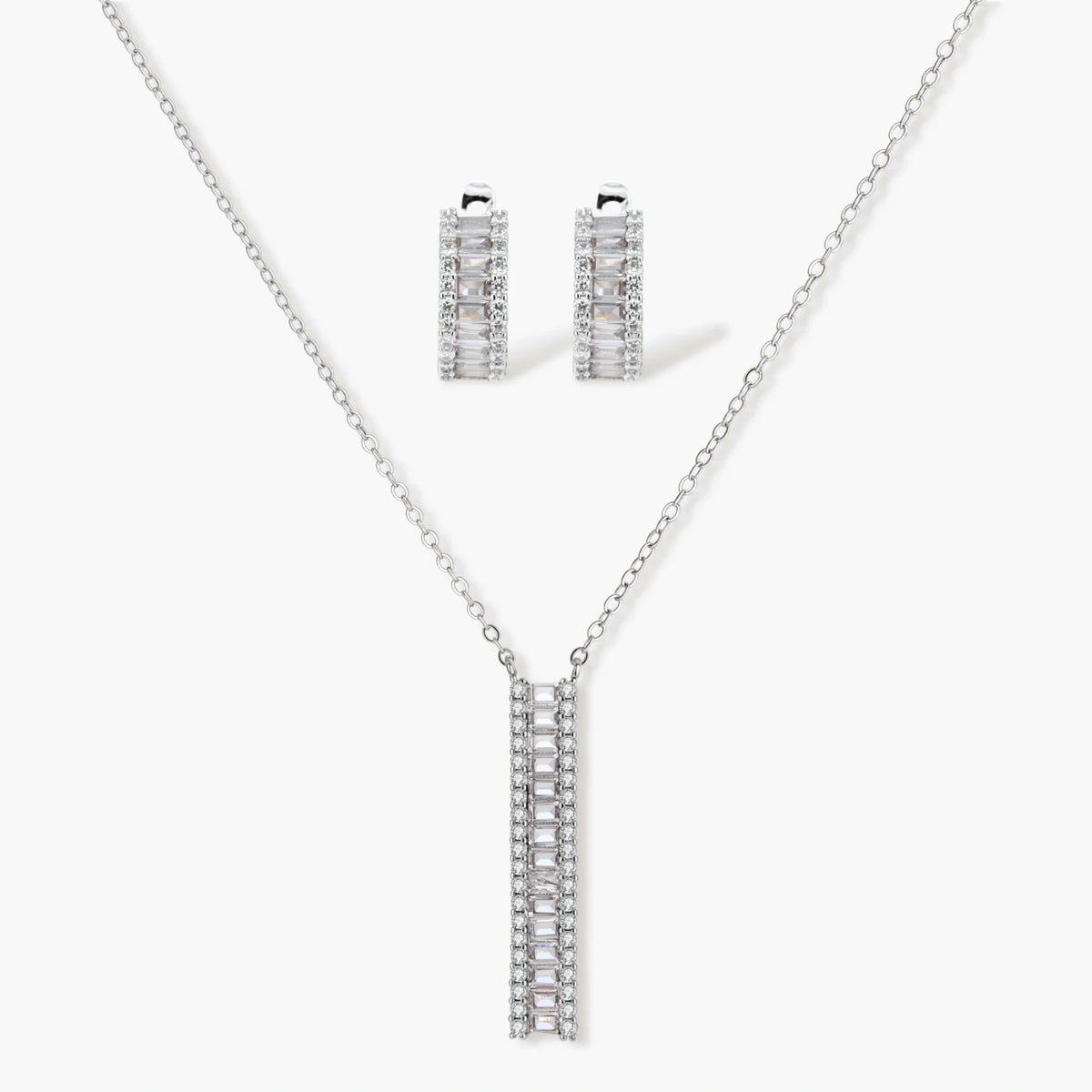 White gold plated necklace with vertical cubic zirconia pendant and matching hoop earrings on neutral background